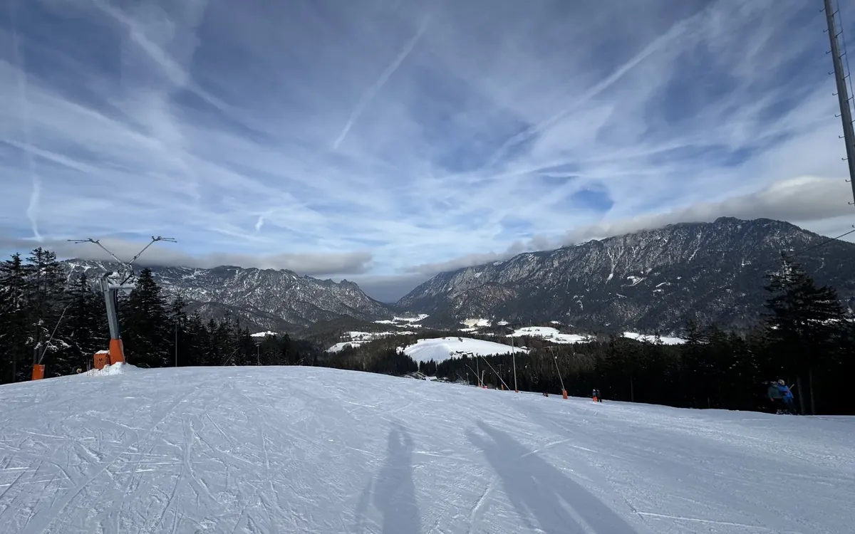 A groomed ski piste above a valley in January